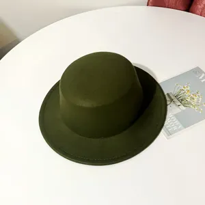 Detail view of dark green wool flat top hat, vintage winter fedora with fine stitching.