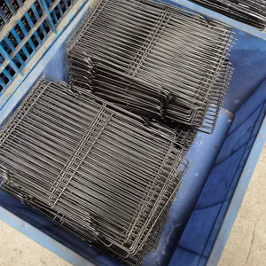 Close-up detail of black metal wire BBQ grill racks stacked neatly in industrial turnover box.