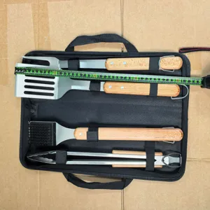 Detail view of the stainless steel BBQ tool set with wooden handles in black storage bag.