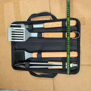 Detail view of 4pcs stainless steel BBQ grill tool set with wooden handles and bag.