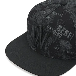 Close-up detail of black flat brim hip-hop cap with embroidered W logo and street text print.