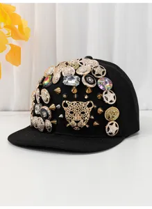 Primo piano dettagliato del cappellino nero di lusso con bottoni in metallo dorato e cristalli.
