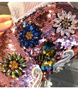 Close-up detail of pink sequin baseball cap with crystal rhinestone flower and bee embellishments.