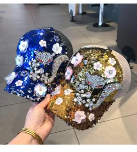 Detailed view of sequin baseball caps featuring rhinestone animal patterns and floral appliques.