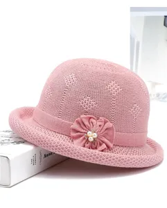Close up of pink knitted bucket hat detail, elegant floral pearl accent, casual spring style.