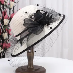 Vue détail du chapeau de soleil élégant pour femmes en noir et blanc avec voile et fleurs.