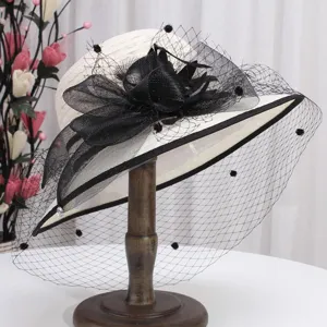 Gros plan detail chapeau de soleil elegant femme avec voile en tulle noir pour voyage.
