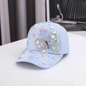 Cappellino da baseball azzurro da donna con farfalla di strass brillanti e protezione solare.