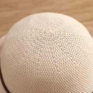 Primer plano detallado del sombrero de paja tejido beige para mujer, mostrando textura fina.