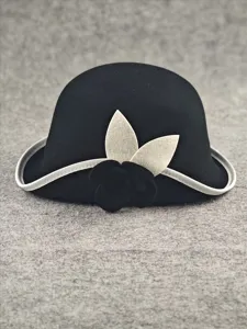 Elegant black wool cloche hat with white trim and chic camellia flower for women fashion.