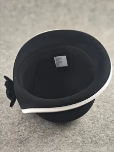 Black wool bucket hat interior detail showing white brim edge and side flower decoration.