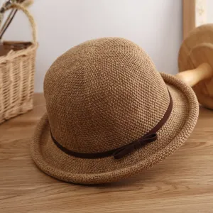 Vista detallada de un sombrero de paja para mujer con cinta marrón, ideal para protección solar.