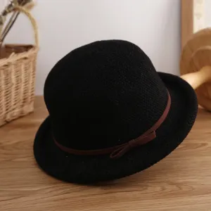Detalle de cerca del sombrero bombín negro clásico con cinta de lazo marrón elegante.