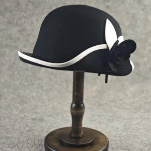 Classic black wool cloche hat with white trim and chic camellia flower decoration for women.