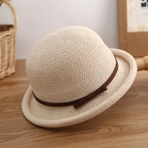 Vista detallada de un elegante sombrero de paja beige con lazo marron para verano.