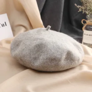 Gros plan détaillé du béret en laine gris classique montrant une texture douce et un tricot fin.