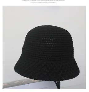 Primo piano dettaglio di cappello secchiello in maglia nera, spessa lana, stile invernale.