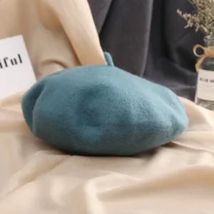 Vue détaillée d'un béret en laine bleu-vert confortable, idéal pour l'automne et l'hiver.