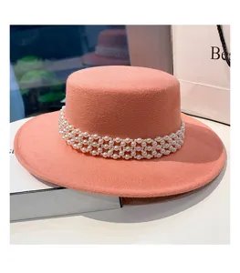 Elegante cappello piatto in feltro rosa con squisita decorazione di catena di perle.