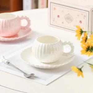 Elegante set di tazza da caffè e piattino in ceramica con manico di perle per il tè pomeridiano.