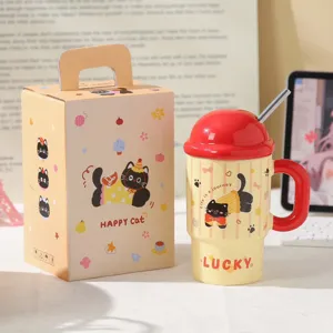 Detail view of a cute cartoon cat ceramic mug with red lid and straw, perfect for desk setup.