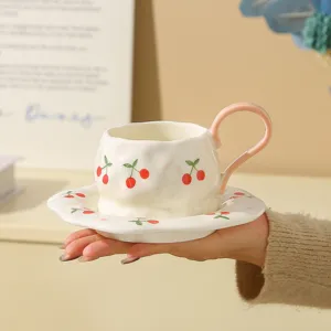 Handmade ceramic coffee cup and saucer set with cute cherry pattern for afternoon tea daily.