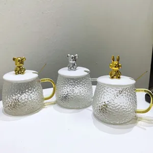 Clear glass mug detail showcasing the cute animal lid, textured cup body and matching spoon.