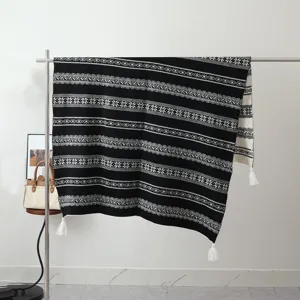 Detailed view of the black and white bohemian knit throw blanket with fringe tassels.
