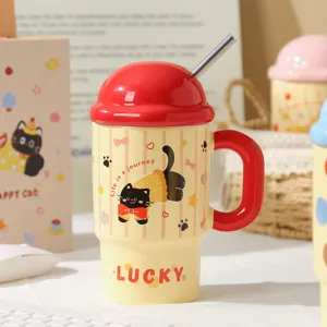 Close-up detail of cute ceramic cat mug with red lid and metal straw, aesthetic table view.