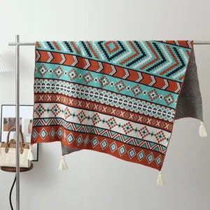 Bohemian ethnic style knitted blanket detail view, geometric pattern throw blanket with fringe.