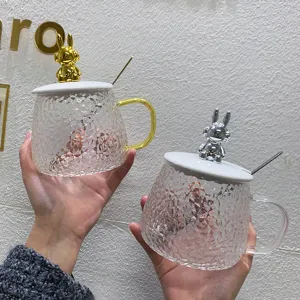 Hammered glass coffee mug with cute gold and silver rabbit lid and spoon for office home use.