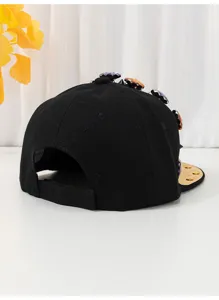 Berretto piatto nero con fiori di cristallo strass e borchie metalliche sulla corona.