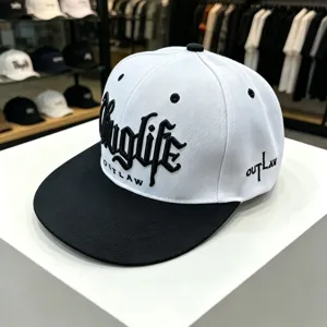 Vista detallada de gorra plana hip-hop en blanco y negro con bordado frontal y lateral.