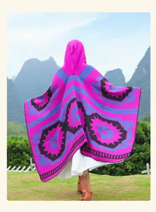 Outdoor ethnic style hooded poncho detail, vibrant pink knit cape for scenic travel photos.