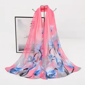 Detailansicht eines rosa Chiffon-Schals mit blauem Blumendruck auf einem Metallständer