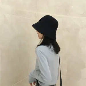 Gedetailleerd overzicht van de zwarte wollen bucket hat met zachte textuur voor de winter.
