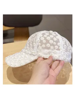 Close-up detail of white lace baseball cap with sweet daisy embroidery, breathable net design.
