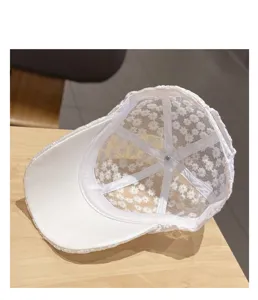 Detailed view of white floral lace baseball cap inner lining, showing breathable mesh structure.