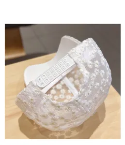 White lace baseball cap featuring delicate daisy embroidery and adjustable snapback closure.