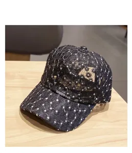 Detail view of black lace baseball cap with white daisy embroidery, breathable summer sun hat.