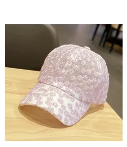 Detail shot of the pink lace baseball cap featuring delicate small daisy embroidery and mesh.