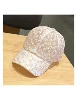 Close-up detail shot of the white lace baseball cap featuring delicate white daisy embroidery.