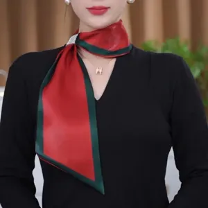 Close-up detail of a stylish red and green silk scarf with rhinestone buckle for women.