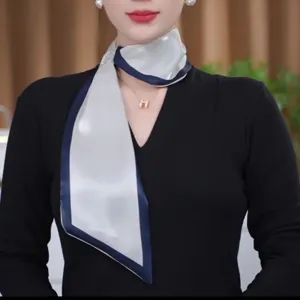 Detailed view of the elegant long silk scarf with rhinestone detail and navy border.