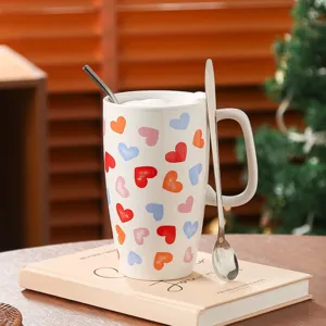 Deliziosa tazza in ceramica con motivo a cuori colorati e cucchiaio, dettaglio per uso domestico.
