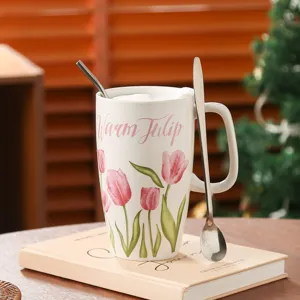 Vista dettagliata di una tazza alta in ceramica con motivo a tulipani e cucchiaio.