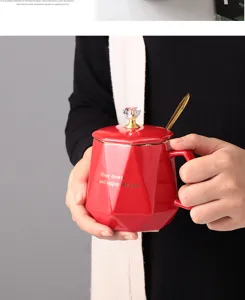 Rote Keramik Kaffeetasse mit Deckel und Löffel, elegantes geometrisches Design.