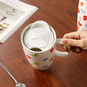 Vista dettagliata della tazza da caffè in ceramica con pois colorati e un coperchio bianco.