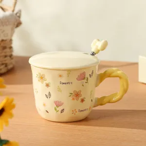 Ceramic mug detail showing romantic floral pattern, cute bow spoon and matching lid on wood.