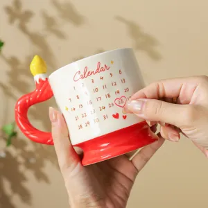 Detailaufnahme der niedlichen Keramiktasse mit Kerzengriff und aufgedrucktem Kalendermotiv.